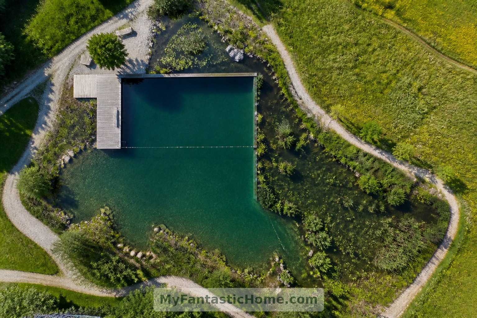 Cette vue aérienne conceptuelle distingue l’espace de baignade, la zone de régénération plantée et les allées du jardin.